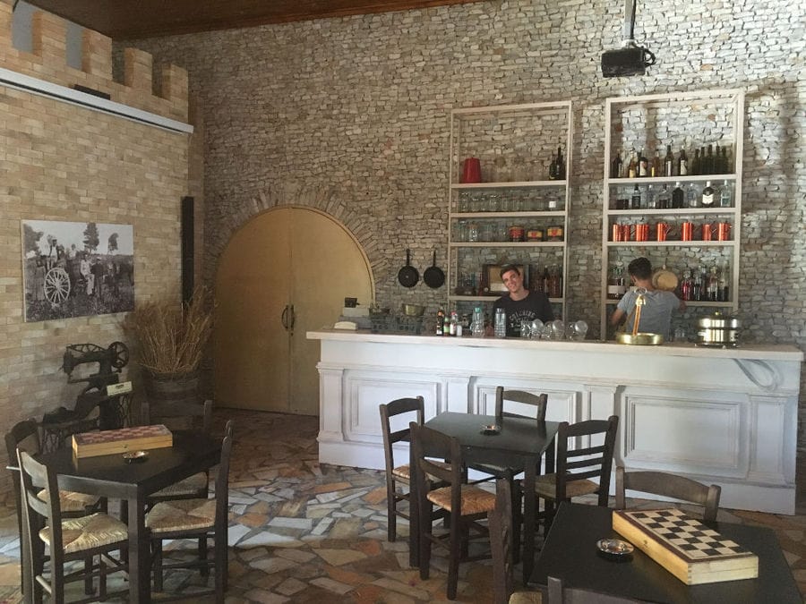 Zahaios wine tasting room with tables and chairs and bottles in the storage locker